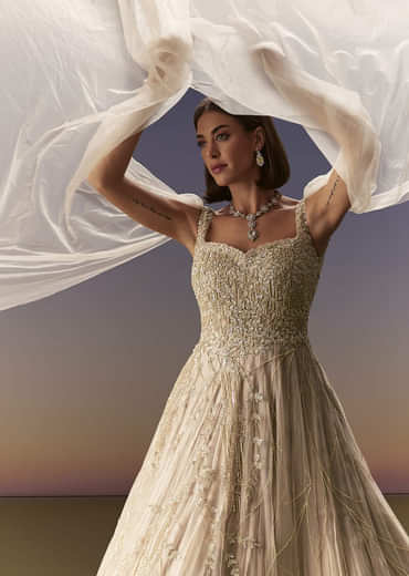 Gold Gown With Pleated Panels And Dramatic Cape