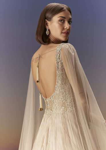 Gold Gown With Pleated Panels And Dramatic Cape