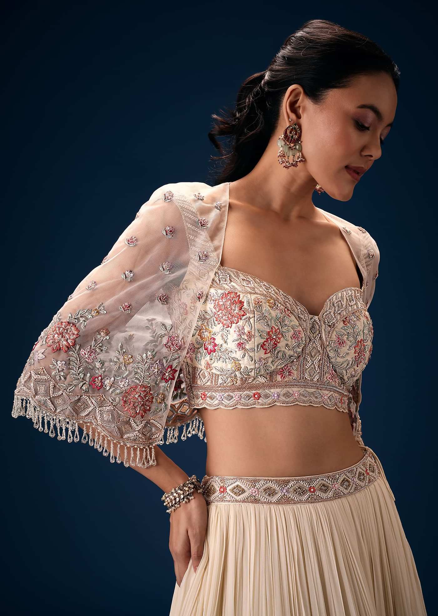 Off White Tiered Lehenga With Embroidered Corset Blouse And Embroidered Cape