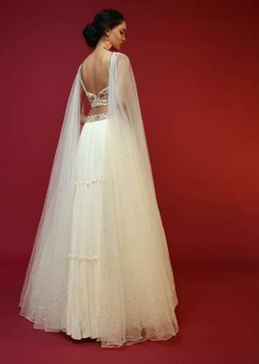 Powder White Lehenga Choli With Attached Cape And Hand Embroidery Using Colorful Resham And Sequins In Floral Motifs