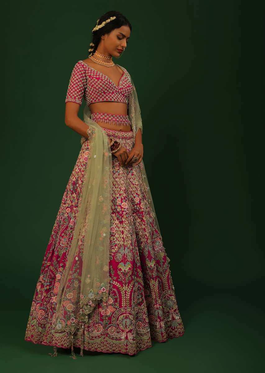 Rani Pink Lehenga Choli In Raw Silk With Heavy Embroidered Kalis Using Colorful Resham And Cut Dana In Floral Motifs Online - Kalki Fashion